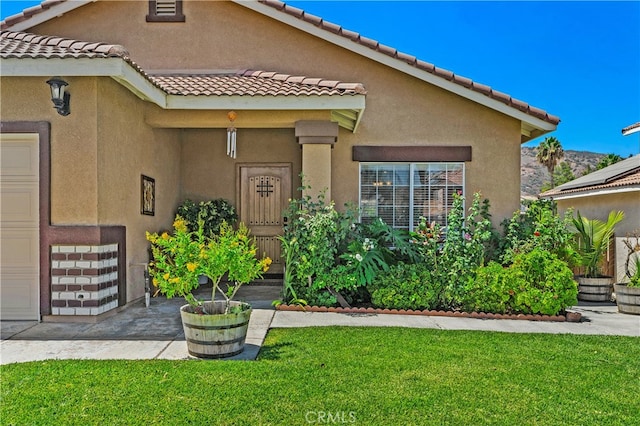 mediterranean / spanish house with a tiled roof, a front lawn, and stucco siding