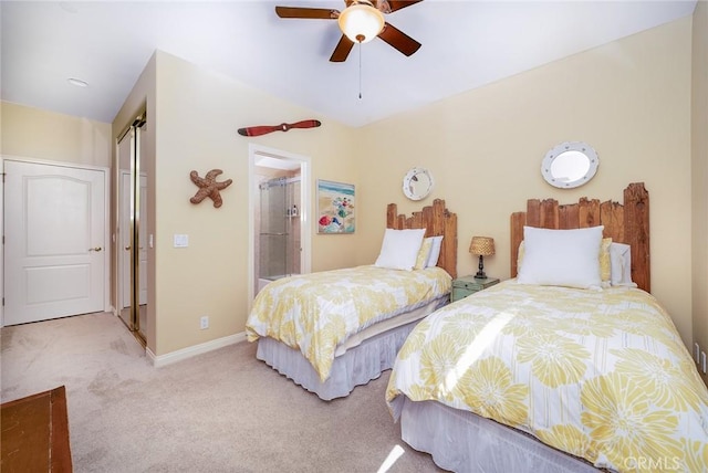 carpeted bedroom with ceiling fan, a closet, and ensuite bath