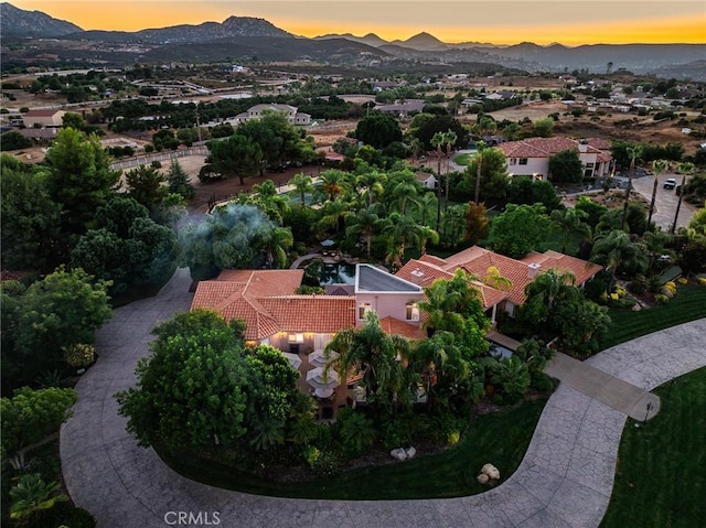 aerial view at dusk featuring a mountain view