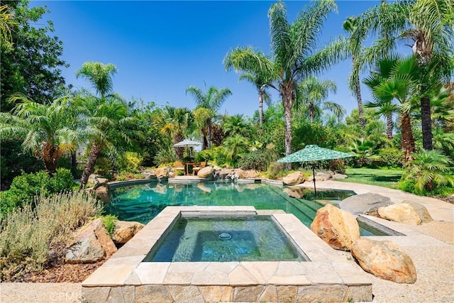 view of swimming pool with an in ground hot tub