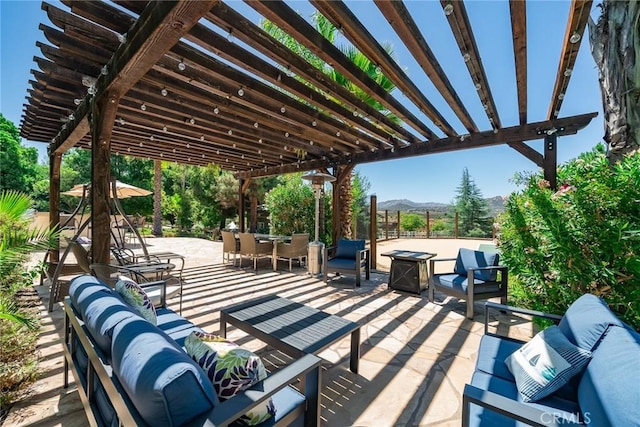 view of patio with outdoor lounge area, a mountain view, and a pergola