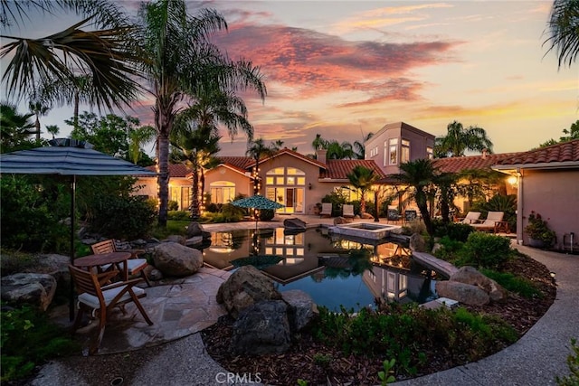 patio terrace at dusk featuring an outdoor fire pit