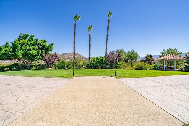 view of property's community featuring a gazebo, a mountain view, and a lawn