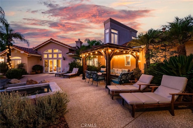 patio terrace at dusk with a gazebo and an outdoor living space