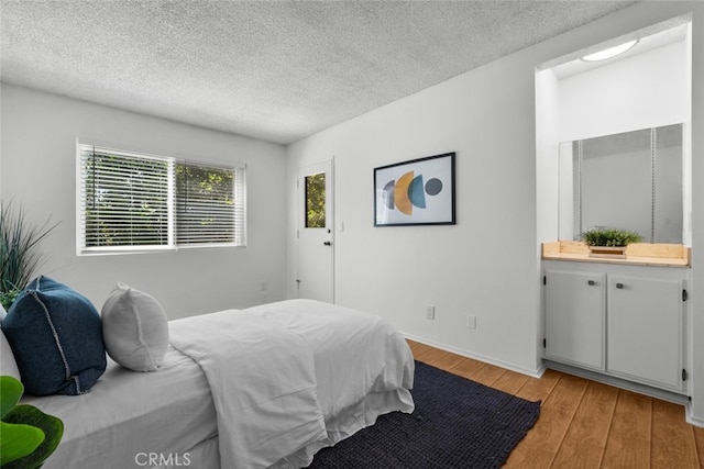 bedroom with a textured ceiling and light wood-type flooring