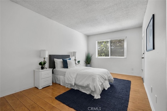 bedroom featuring light hardwood / wood-style floors and a textured ceiling