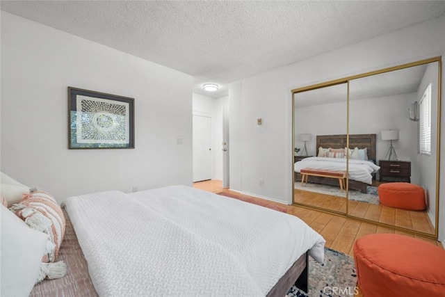 bedroom featuring a textured ceiling, hardwood / wood-style flooring, and a closet