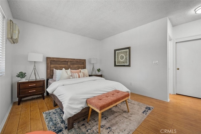 bedroom featuring light hardwood / wood-style floors and a textured ceiling