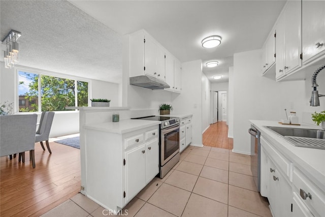 kitchen featuring white cabinets, a textured ceiling, light hardwood / wood-style flooring, sink, and stainless steel appliances