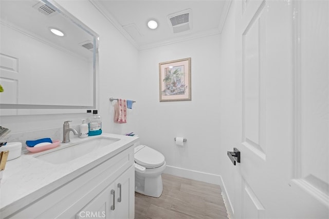 bathroom with ornamental molding, vanity, hardwood / wood-style floors, and toilet