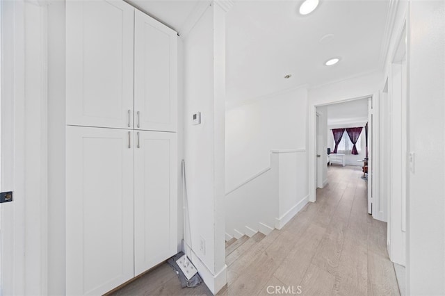 hallway featuring crown molding and light hardwood / wood-style flooring