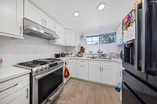 kitchen featuring light hardwood / wood-style flooring, stainless steel appliances, white cabinetry, and sink