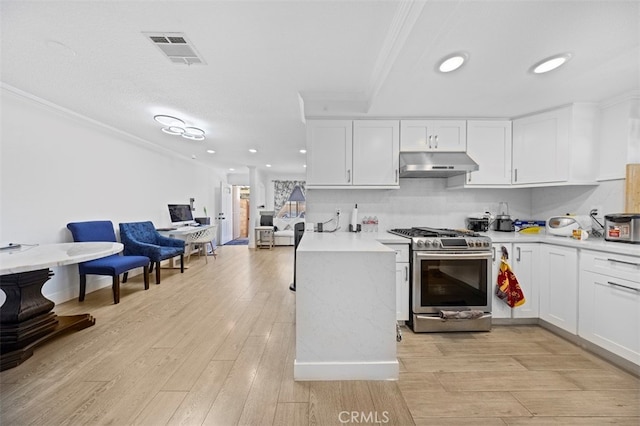 kitchen with light hardwood / wood-style flooring, white cabinetry, stainless steel range with gas cooktop, and crown molding