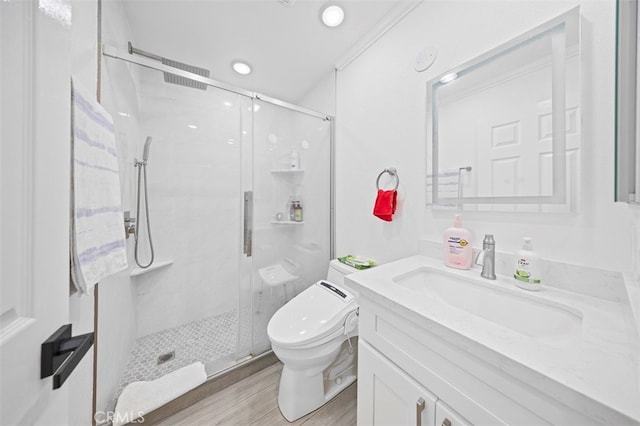 bathroom with vanity, ornamental molding, hardwood / wood-style flooring, toilet, and a shower with door