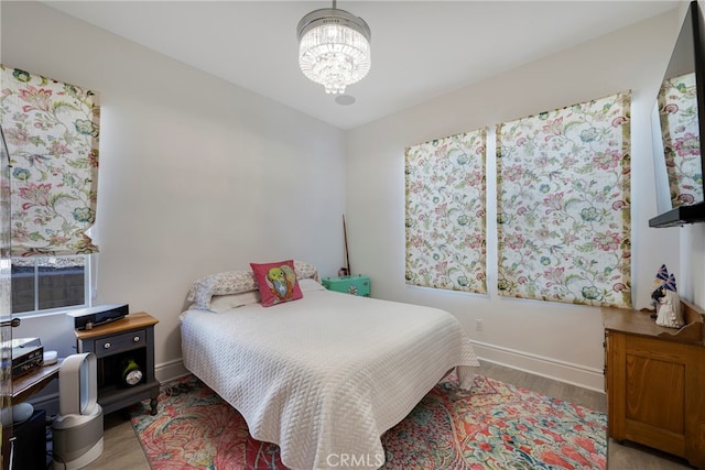 bedroom with light wood-type flooring and a chandelier