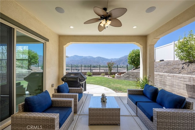 view of patio with ceiling fan, a mountain view, an outdoor living space, and grilling area