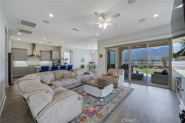 living room with light wood-type flooring, a mountain view, and ceiling fan