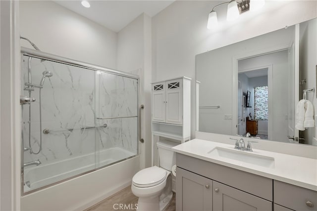 full bathroom featuring shower / bath combination with glass door, vanity, and toilet