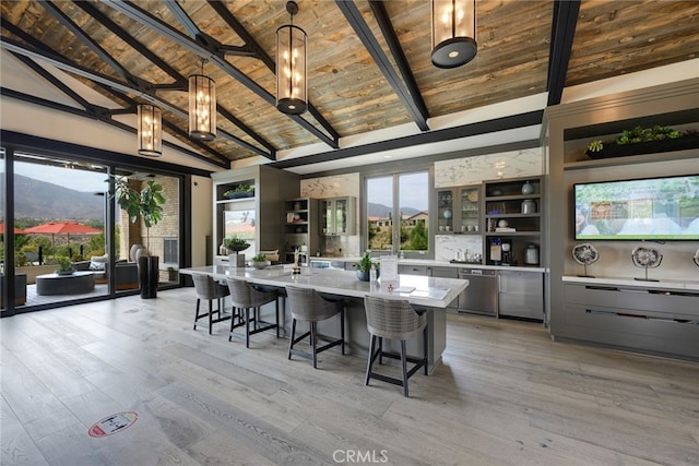 kitchen featuring gray cabinets, wood ceiling, light wood-type flooring, a large island with sink, and vaulted ceiling with beams