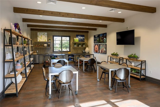 dining space with dark hardwood / wood-style floors and beam ceiling