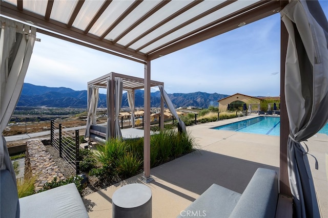 view of swimming pool featuring a patio, a mountain view, and a pergola