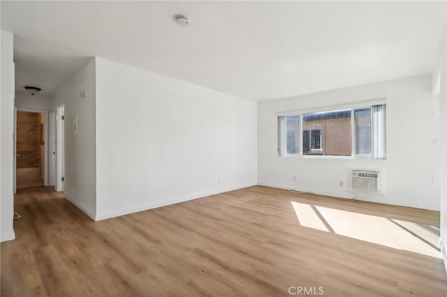 empty room with light hardwood / wood-style flooring and a wall mounted AC