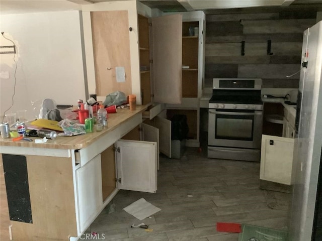 5645 Cahuilla Ave Unit 29, Palms, CA 92277 - kitchen featuring stainless steel range oven, wood finished floors, white cabinetry, and light countertops