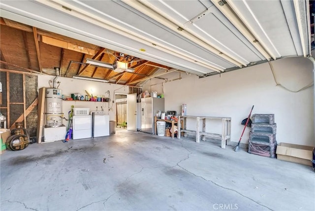 garage with washer and clothes dryer, secured water heater, stainless steel refrigerator with ice dispenser, and a garage door opener