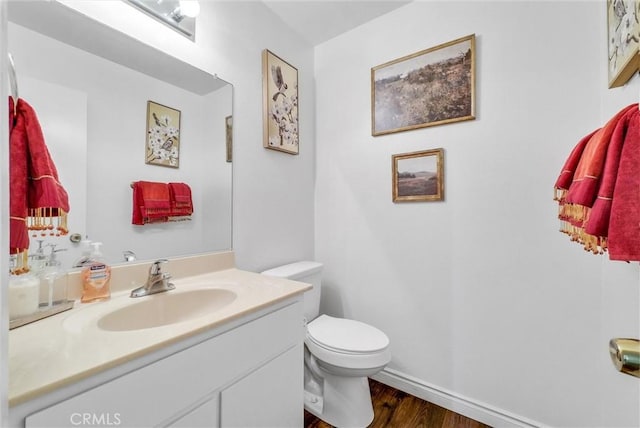 bathroom with wood-type flooring, vanity, and toilet