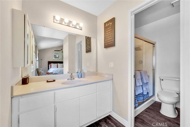 bathroom featuring vanity, a shower with door, hardwood / wood-style floors, toilet, and lofted ceiling