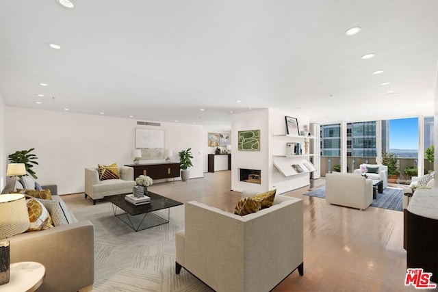 living room featuring light hardwood / wood-style floors, a fireplace, and expansive windows