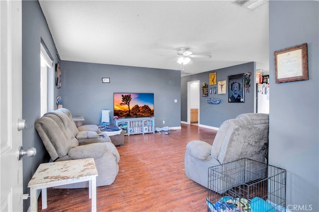 living room with hardwood / wood-style floors, a textured ceiling, and ceiling fan