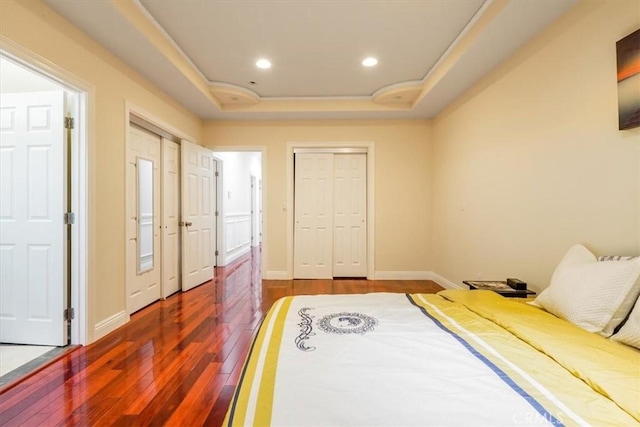 bedroom with hardwood / wood-style floors and a tray ceiling