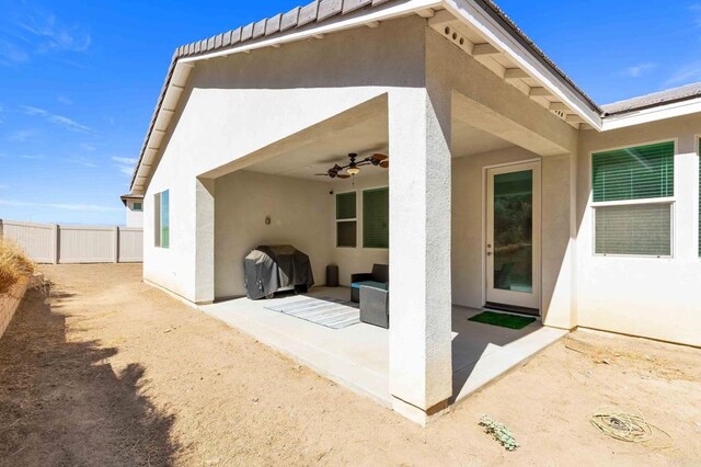 rear view of house with ceiling fan and a patio area