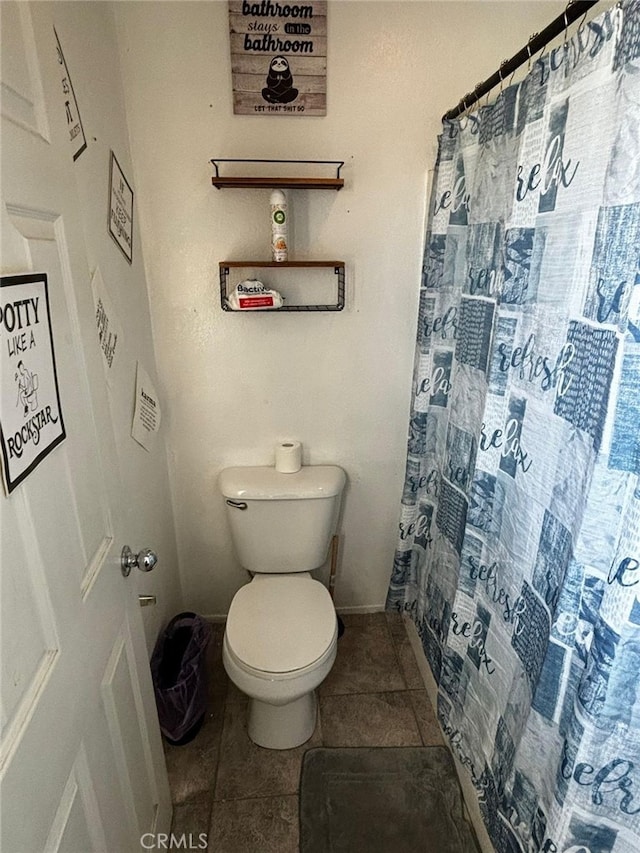 bathroom with tile patterned flooring, toilet, and a shower with curtain