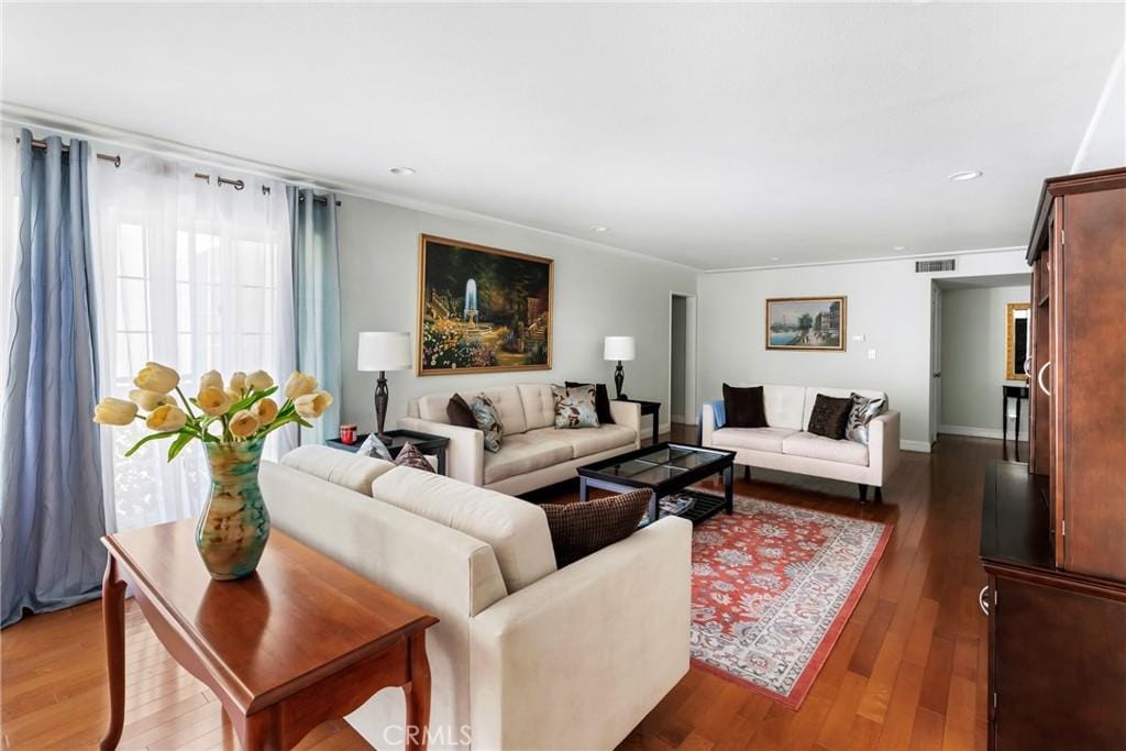 living room featuring dark hardwood / wood-style floors and crown molding