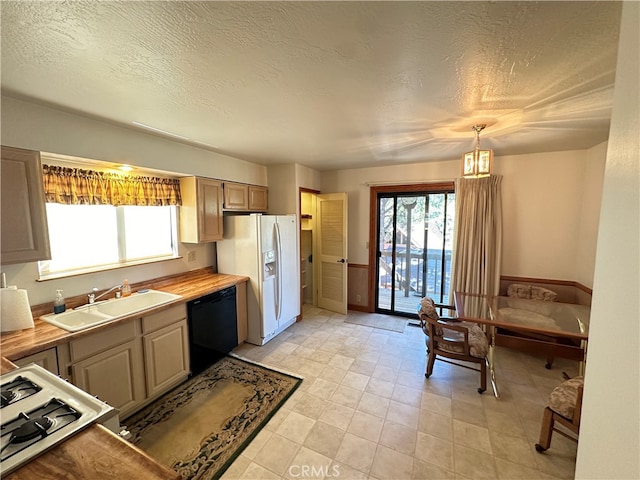 kitchen with a textured ceiling, wood counters, sink, hanging light fixtures, and white appliances