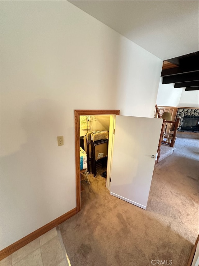 corridor with light carpet and vaulted ceiling with beams