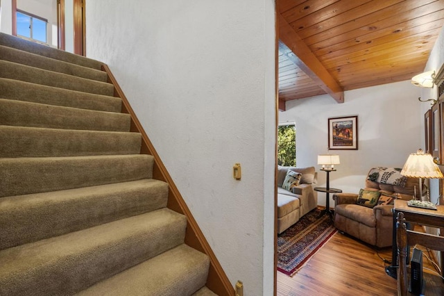 stairs with hardwood / wood-style floors, beamed ceiling, and wood ceiling