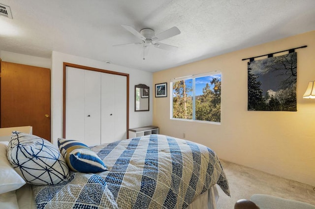 carpeted bedroom with ceiling fan and a closet