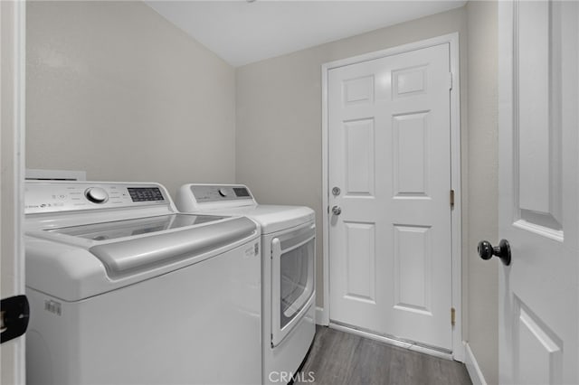 laundry area with dark hardwood / wood-style flooring and independent washer and dryer