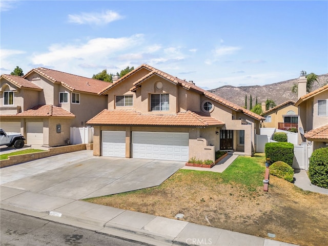 mediterranean / spanish-style home with a mountain view and a garage