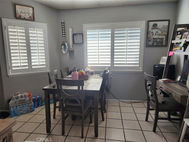 dining room with light tile patterned flooring and a textured ceiling