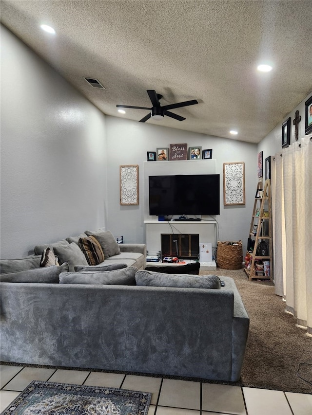 tiled living room featuring a textured ceiling, lofted ceiling, and ceiling fan