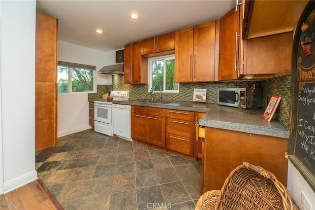 kitchen with a wealth of natural light, white appliances, sink, and range hood