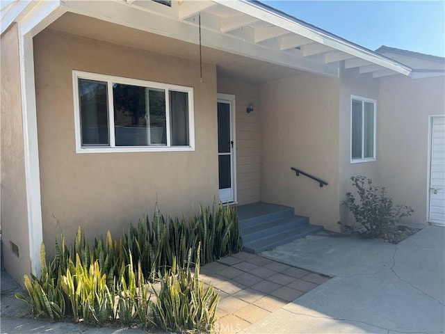 property entrance with stucco siding