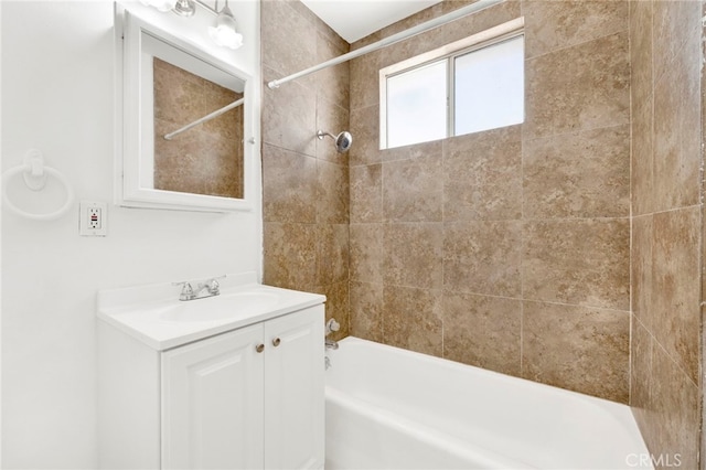 bathroom featuring tiled shower / bath and vanity