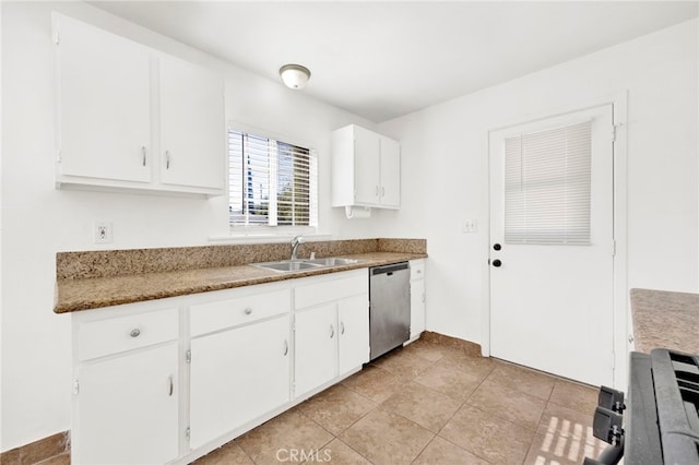 kitchen featuring stainless steel dishwasher, white cabinetry, sink, and light tile patterned floors