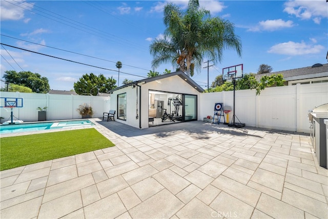 rear view of property featuring a fenced in pool, an outdoor structure, and a patio area