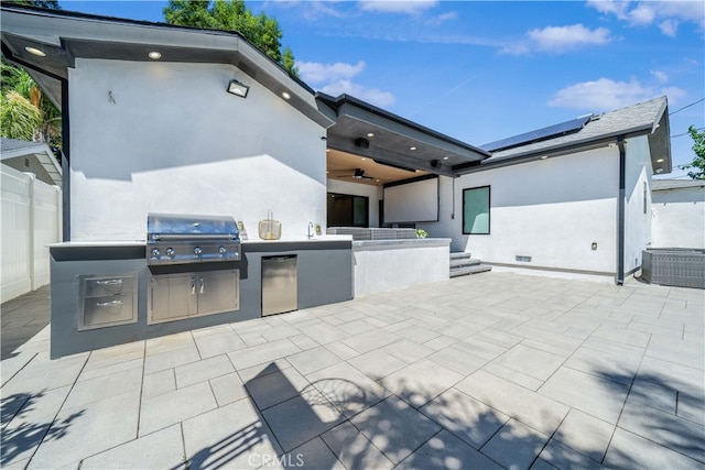 view of patio featuring area for grilling, sink, ceiling fan, and an outdoor kitchen